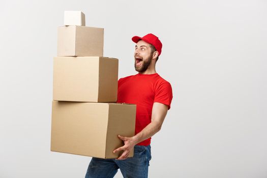 Delivery man doing surprise gesture holding cardboard boxes