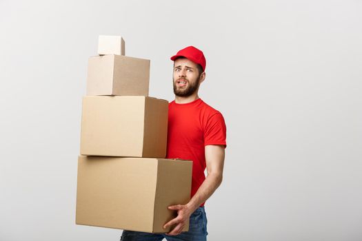 Delivery man doing worry gesture holding cardboard boxes
