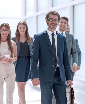 businessman walking in front of his business team . business concept