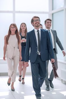 businessman walking in front of his business team . business concept