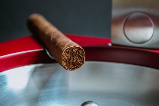 Close view of a cigar on an ashtray with a cutter. Macro shot