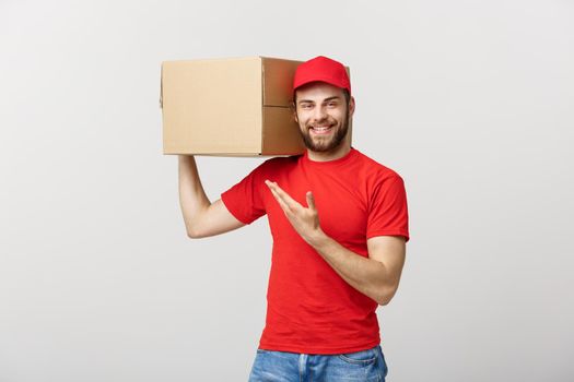 Delivery Concept - Portrait of Happy Caucasian delivery man pointing hand to present a box package. Isolated on Grey studio Background. Copy Space