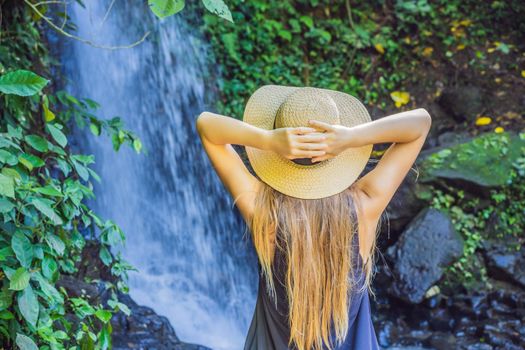 Woman traveler on a waterfall background. Ecotourism concept.