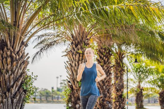 Runner athlete running at tropical park. woman fitness sunrise jogging workout wellness concept.