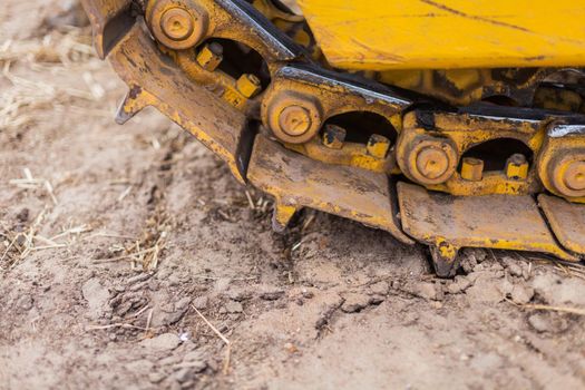 Close-up of crawler bulldozer truck. Earthmoving heavy machinery. Yellow crawler machinery. Yellow Tractor on caterpillar tracks, tractor tracks