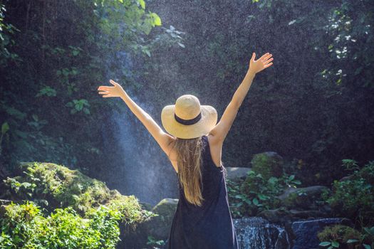 Woman traveler on a waterfall background. Ecotourism concept.