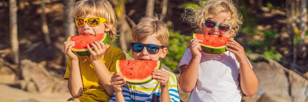 Children eat watermelon on the beach in sunglasses. BANNER, LONG FORMAT