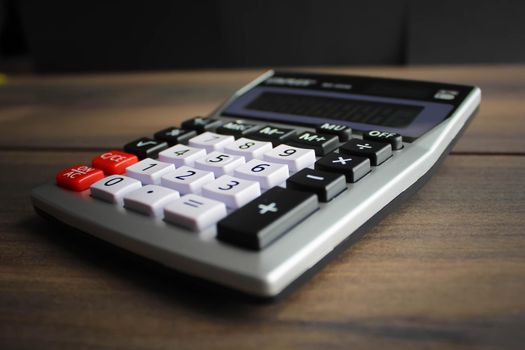 Calculator keypad on a wooden floor background. Top view. Copy space