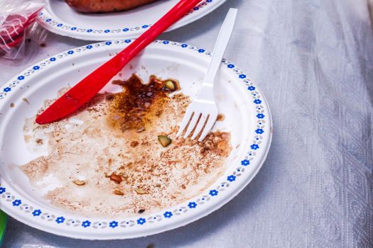 Empty dirty plastic plates with spoon on a white background. Ecology Concept for Earth Hour, Earth Day, Ocean Day and other ECO dates.