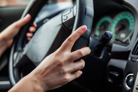 A woman is driving, women's hands are on the handlebars.