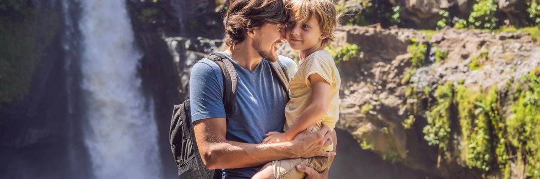 Dad and son tourists on the background of a waterfall. Traveling with kids concept. What to do with children Children friendly place. BANNER, LONG FORMAT