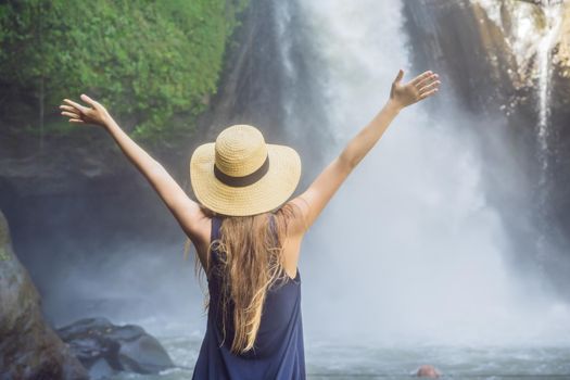 Woman traveler on a waterfall background. Ecotourism concept.