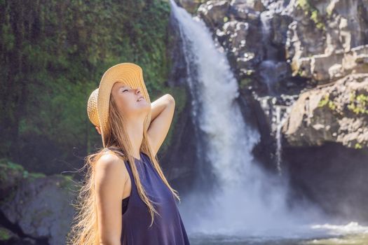 Woman traveler on a waterfall background. Ecotourism concept.