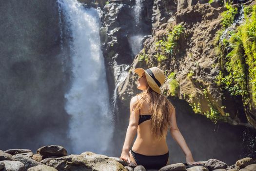 Woman traveler on a waterfall background. Ecotourism concept.
