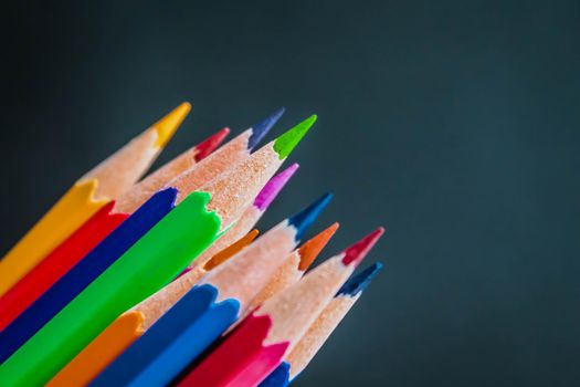 Back to school concept with black chalkboard background with colorful wooden pencils