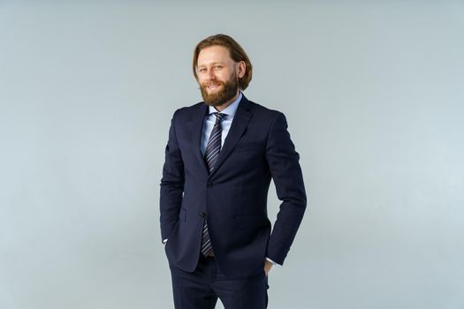 a handsome brutal bearded and long-haired man, a stylish businessman on a white background. High quality photo