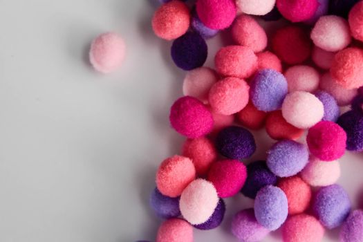 close up colorful pom poms texture background, heap of small pastel color fluffy ball for crafts and fashion accessories decoration, selective focus