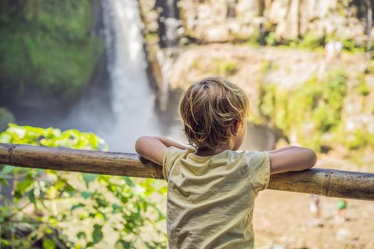 Boy traveler on a waterfall background. Ecotourism concept. Traveling with kids concept. What to do with children. Child friendly place.