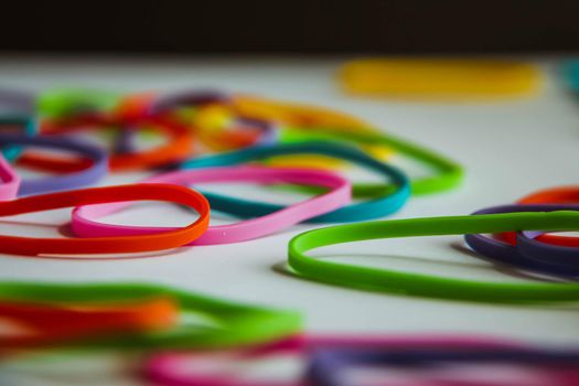 Side view of colorful rubber bands on white. Rainbow elastic rubber bands on white.