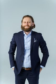 a handsome brutal bearded and long-haired man, a stylish businessman on a white background. High quality photo