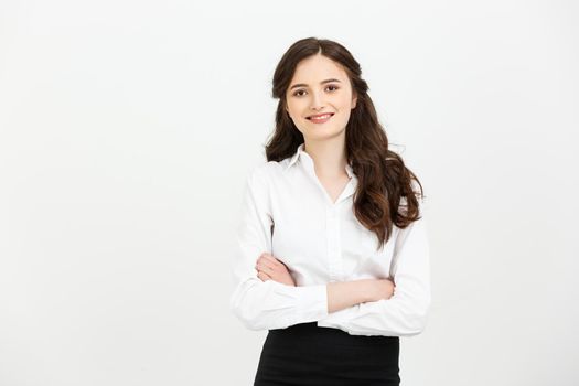 Business Concept: Portrait confident young businesswoman keeping arms crossed and looking at camera while standing against grey background.