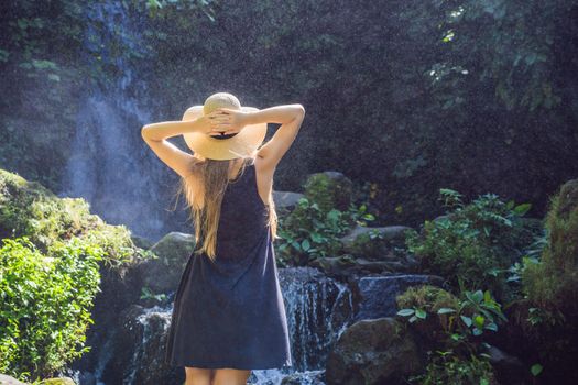 Woman traveler on a waterfall background. Ecotourism concept.
