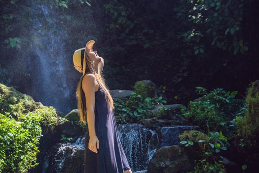 Woman traveler on a waterfall background. Ecotourism concept.