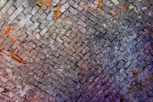 The vaulted ceiling of an ancient temple made of red brick.