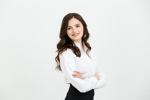 Business Concept: Portrait confident young businesswoman keeping arms crossed and looking at camera while standing against grey background.
