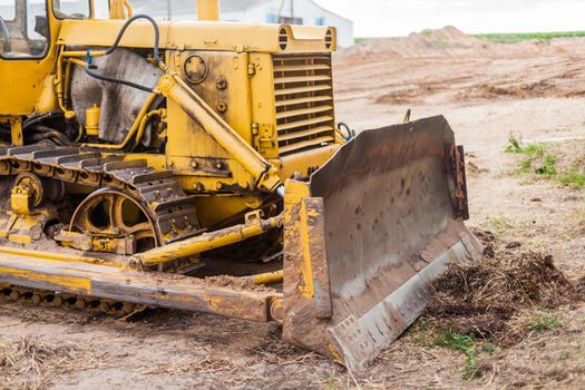 Close-up of crawler bulldozer truck. Earthmoving heavy machinery. Yellow crawler machinery. Yellow Tractor on caterpillar tracks, tractor tracks
