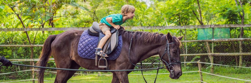 Boy horseback riding, performing exercises on horseback. BANNER, LONG FORMAT