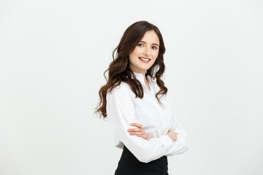 Business Concept: Portrait confident young businesswoman keeping arms crossed and looking at camera while standing against grey background.