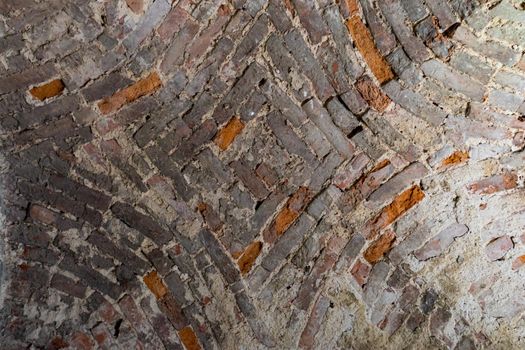 The vaulted ceiling of an ancient temple made of red brick.