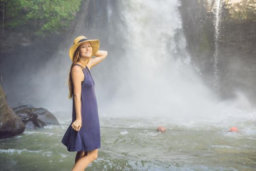 Woman traveler on a waterfall background. Ecotourism concept.