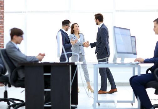 Businessman signing contract while his partner is looking at him in cosy meeting room