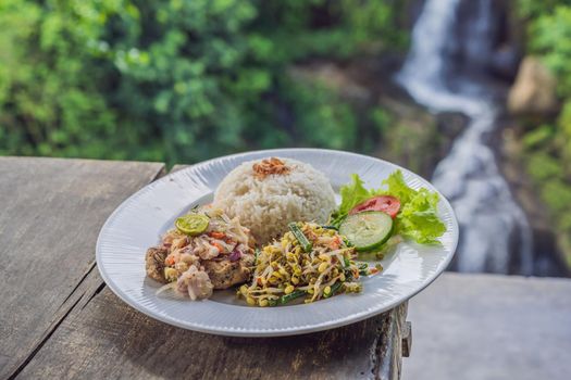 Indonesian food, tuna and rice in a cafe on the background of a waterfall.