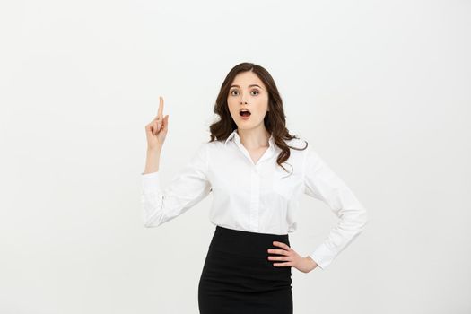 Business Concept: Attractive young Caucasian girl open her mouth and pointing her index finger to the top. She looks enthusiastic, isolated on white background.