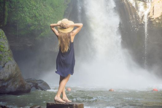 Woman traveler on a waterfall background. Ecotourism concept.