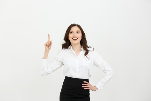 Business Concept: Attractive young Caucasian girl open her mouth and pointing her index finger to the top. She looks enthusiastic, isolated on white background.