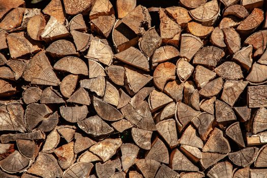 Background of dry chopped firewood logs in a pile