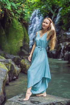 Woman traveler on a waterfall background. Ecotourism concept.
