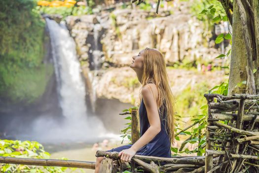 Woman traveler on a waterfall background. Ecotourism concept.
