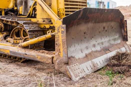 Grader tractor on caterpillars of yellow color