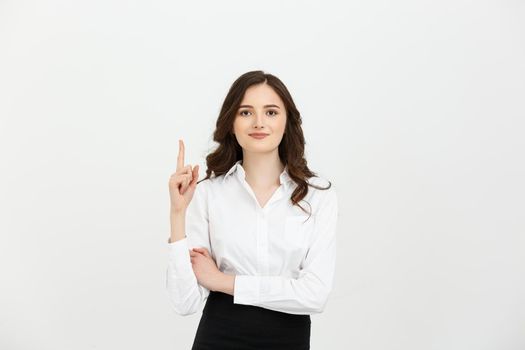 Business Concept: Attractive young Caucasian girl open her mouth and pointing her index finger to the top. She looks enthusiastic, isolated on white background.