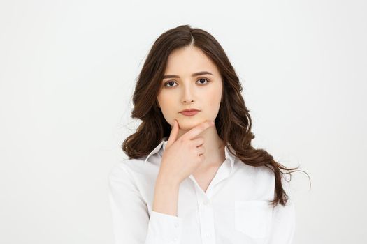 Thinking Caucasian business woman with hand on her chin and looking up on grey backgroud