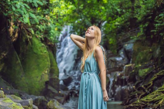 Woman traveler on a waterfall background. Ecotourism concept.