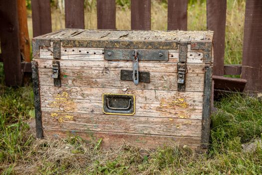 Old wooden storage chest on the grass.