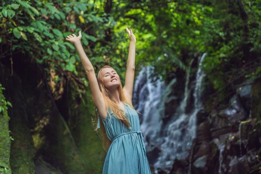 Woman traveler on a waterfall background. Ecotourism concept.