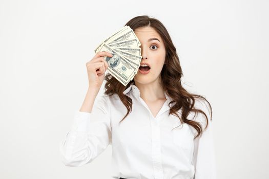 Portrait shocked young business woman standing and holding money isolated over white background