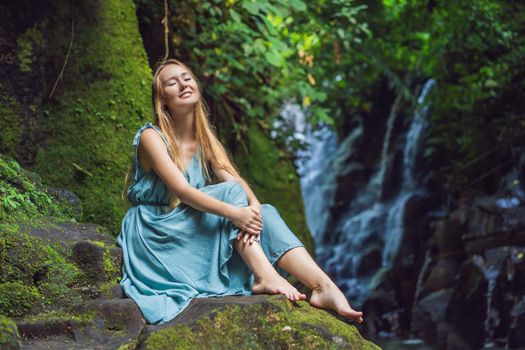 Woman traveler on a waterfall background. Ecotourism concept.
